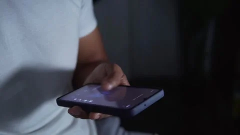 Person doomscrolling on a smartphone at night Stock Footage 344756562