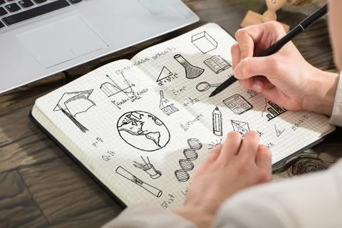 Person Drawing Educational Elements In Notebook 스톡 사진