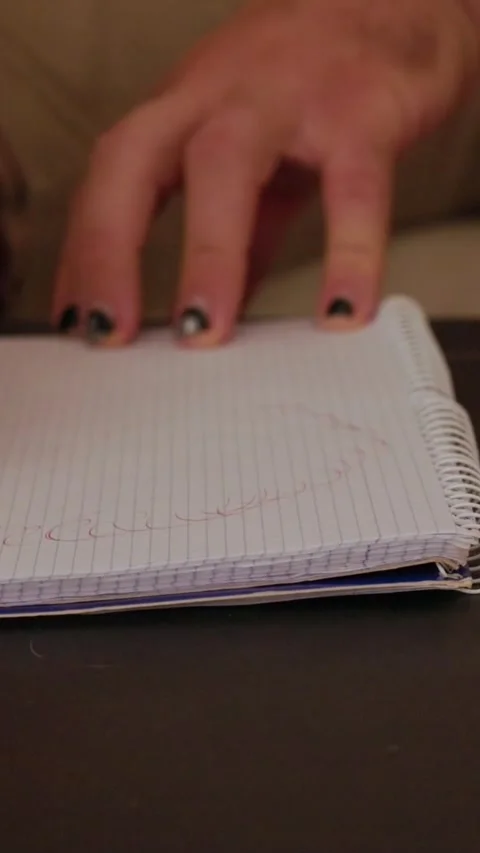 Person drawing face on notepad on table Stock Footage 327862714