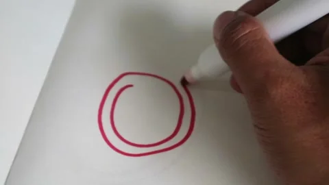 A person drawing a red circle on white paper with a marker. Stock Footage 341956087