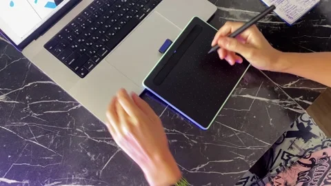 Person drawing on tablet, overhead view, then leaving the desk Stockbeeldmateriaal 346743114