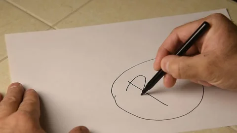 A person draws bitcoin on paper. Stock Footage 145087285