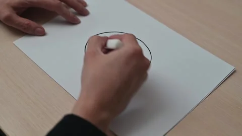 A person draws a circle on a sheet of paper and then divides the circle into Видео 337550137