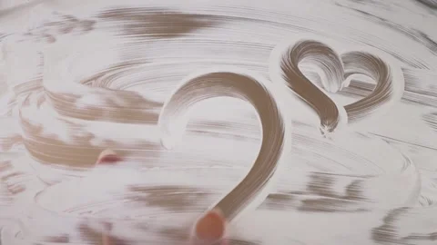 A person draws hearts on a transparent surface Stock Footage 143236052