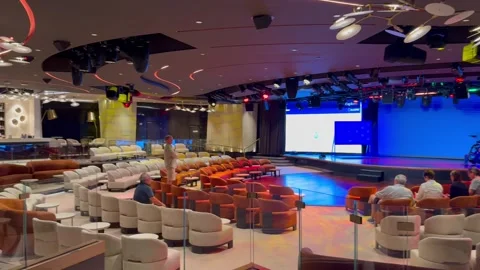 A person driving a formula 1 simulator at the theatre on a Cruise. Stock Footage 327879556