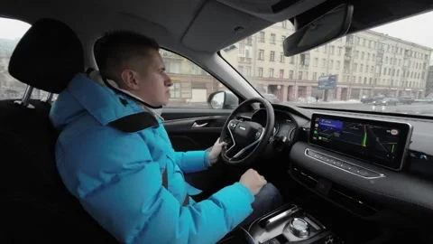 A person is driving a modern car while navigating through a winter city Vídeo Stock 291510679