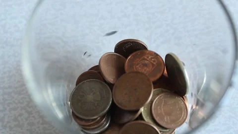 Person Dropping Coins into a Glass for Saving Concept. Vídeo Stock 345639973