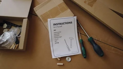 Person dropping instructions for assembling flat pack furniture 動画素材 347030176