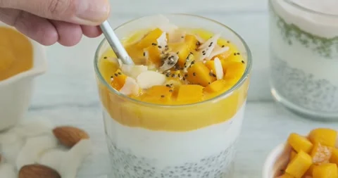 Person eating chia pudding with mango, yogurt and chia seeds. Creamy smoothie Stock Footage 249302228