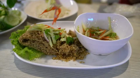 Person eating crispy catfish with Mango salad,Thai food Stock Footage 232584438