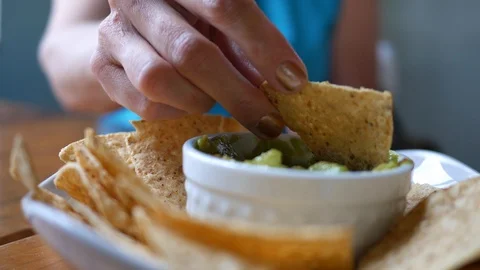 Person eating guacamole while scooping a chip Stock Footage 90365355