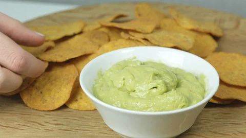 Person eating guacamole while scooping a chip Stock Footage 126936724