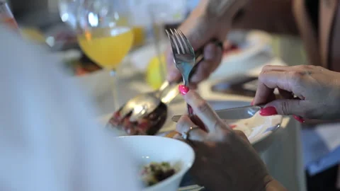 The person eats food at the table, fork and knife in hands Stock Footage 252829666