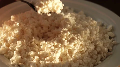 Person eats fresh cottage cheese with a spoon, closeup Stock Footage 134398992