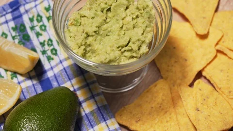 Person eats guacamole with nachos chips at a party, close-up. Delicious snack 動画素材 125866490