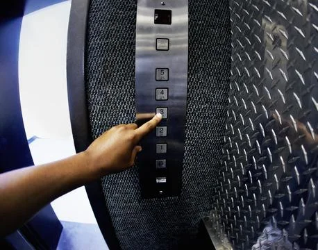 Person, elevator and button with hand to floor going up in hotel building Foto stock