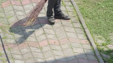 A Person Engaged in the Activity of Sweeping the Sidewalk with a Broom Tool in Stock Footage 311281643