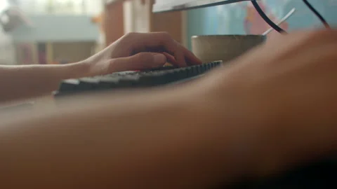 Person engaged in coding with coffee nearby in natural daylight Stock Footage 325073668