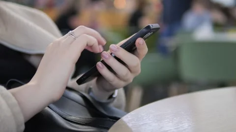 Person engaged with mobile device in relaxed public space Stock Footage 342029620
