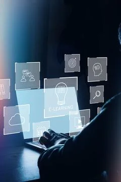 Person engaging in e-learning while using a laptop at night with digital icons Stock Photos