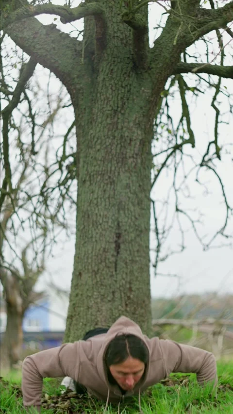 Person Engaging in Exercise Activities Outdoors Next to a Tree in a Natural Video stock 302658331