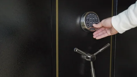 Person entering code to gun safe door, opening vault and removing handgun Stockbeeldmateriaal 126791781