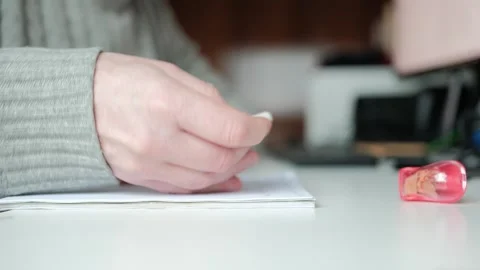 Person erasing a mistake while writing with pencil on paper notebook Stock Footage 344527893