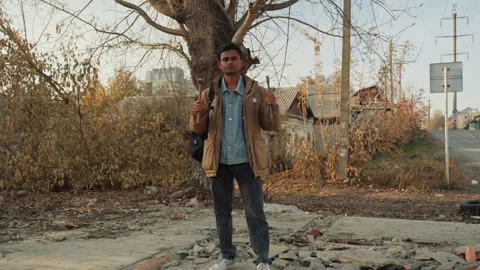 Person evaluating rubble near roadside tree and debris. Worker in jacket Stock Footage 338006317