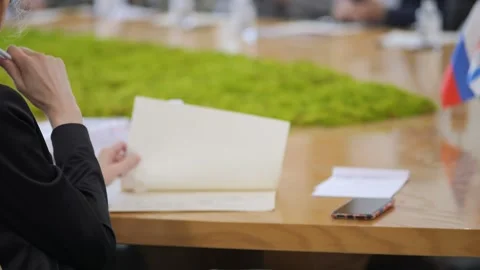 Person examines papers during formal meeting Stock Footage 341456705
