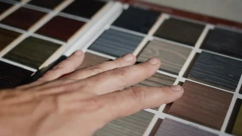 Person examining wooden material samples on color palette card for interior.. Stock-Footage 334594030