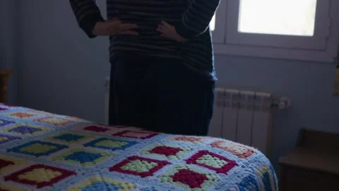 Person experiencing back pain getting out of bed 库存影片 332048903