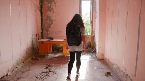 Person exploring abandoned building with deteriorating pink walls, natural light Video stock 342087674