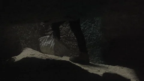Person exploring a dark and narrow cave passage Video stock 336752228