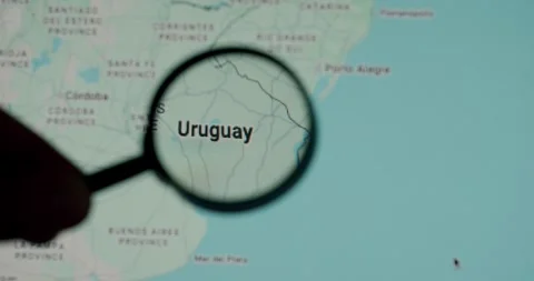 Person exploring Uruguay on a digital map with a magnifying glass Stock Footage 345589859