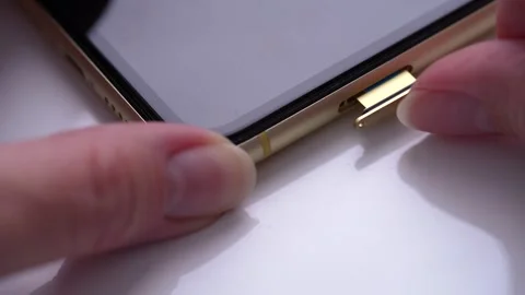 Person extract a sim card from a mobile phone, Sim card in tray being inser.. Stock Footage 245471050