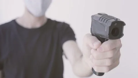 Person with face mask points digital infrared temperature laser measuring device Stock Footage 135252538