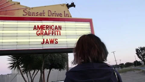 Person facing drive in marquee of Jaws and American Graffiti Stock Footage 150381598