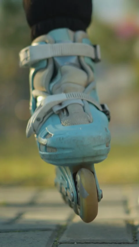 Person Fastening Rollerblade Straps While Sitting in Park Stock Footage 310492619