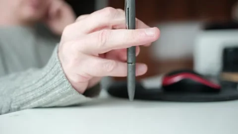 Person fidgeting with a pen while sitting at a desk Stock Footage 344527900