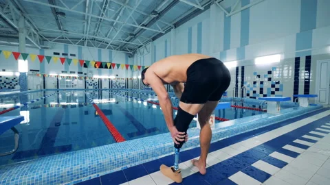 Person fixes a prosthesis after swimming, back view. Stock Footage 101229929