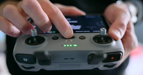 Person flying a drone using a remote controller with a smartphone Stock Footage 343930649