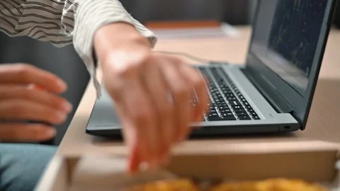 A person is focused on typing on a laptop at a table. They are reaching for Stock Footage 339005725