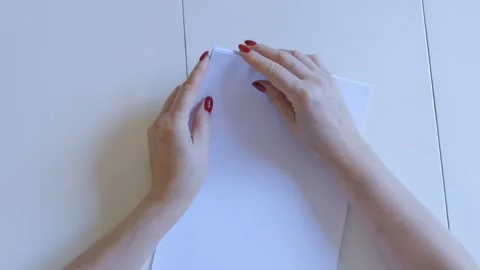 Person is folding a piece of paper Stock Footage 327659675
