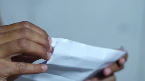 Person folding a white sheet of paper into a fan shape, creating creases Stock Footage 345979735