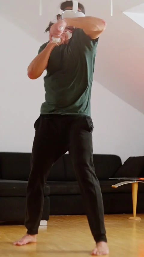 A person fully engaged in a captivating virtual reality gaming experience that Stock Footage 302654814