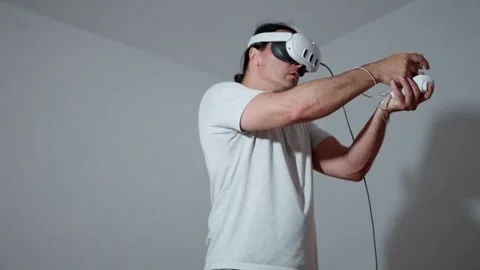 A person is fully immersed in an exciting virtual reality gaming session while Stock Footage 311448536