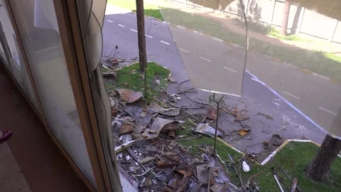 A person gazes out a window at a broken window in a building Stock Footage 264302522