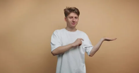 Person gestures with hands in front of a plain background while showing dif.. Stockbeeldmateriaal 328247141