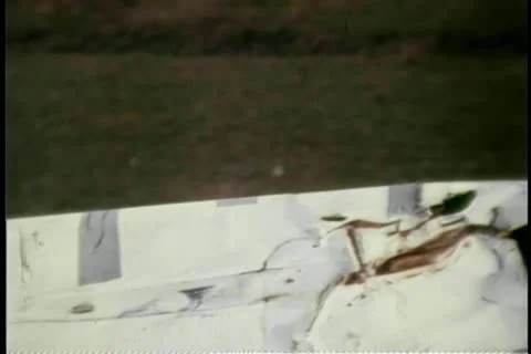 Person gesturing thumbs up from behind overturned car Video stock 25207557