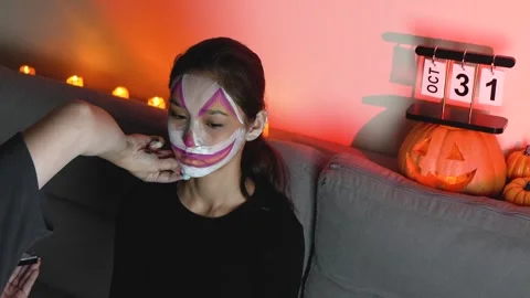 A person is getting their face painted with Halloween makeup Stock Footage 319825964